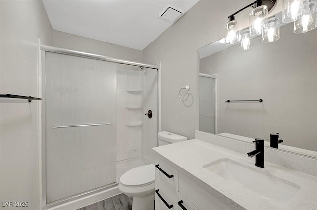 full bath featuring toilet, a shower stall, wood finished floors, and vanity