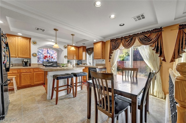 dining room featuring a raised ceiling and recessed lighting