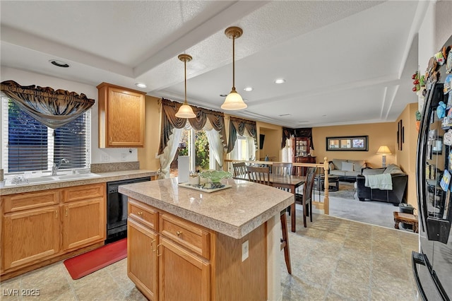 kitchen featuring a sink, dishwasher, light countertops, a kitchen island, and pendant lighting