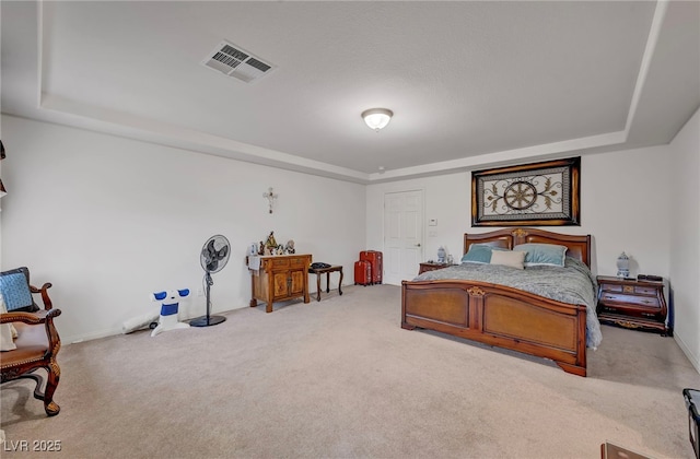 bedroom with a tray ceiling, carpet flooring, and baseboards