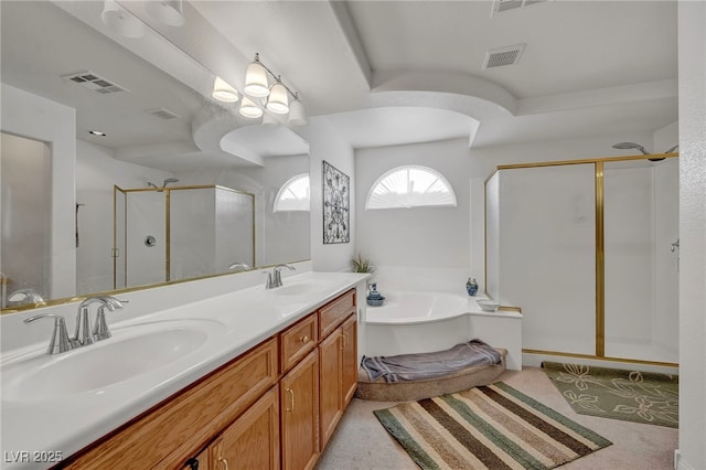 bathroom with a stall shower, a garden tub, and double vanity