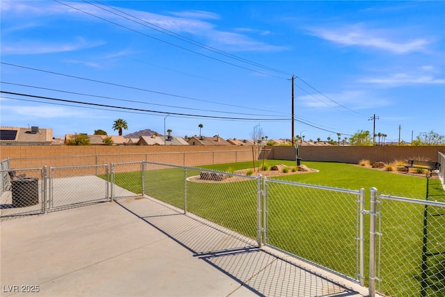 view of yard with a gate and central AC