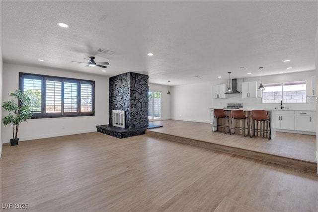 405 Oil Lantern Ln, Las Vegas, NV 89145 - living room featuring recessed lighting, light wood finished floors, baseboards, ceiling fan, and a textured ceiling