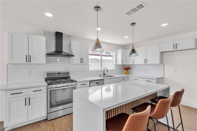 405 Oil Lantern Ln, Las Vegas, NV 89145 - kitchen featuring stainless steel appliances, wall chimney exhaust hood, light wood-style floors, a sink, and recessed lighting