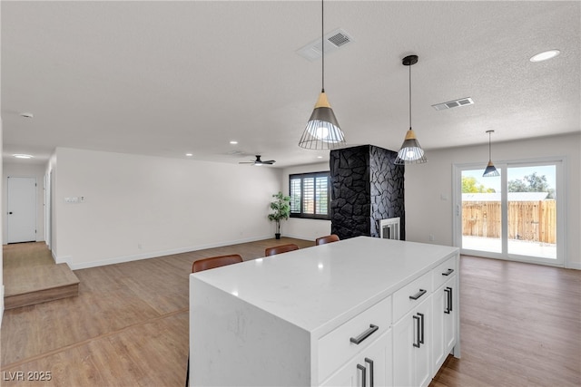 405 Oil Lantern Ln, Las Vegas, NV 89145 - kitchen with light wood-type flooring, a center island, light countertops, white cabinets, and recessed lighting