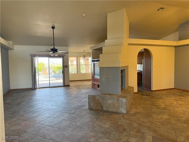 4455 W Ford Ave, Las Vegas, NV 89139 - unfurnished living room featuring ceiling fan, arched walkways, a tiled fireplace, and lofted ceiling
