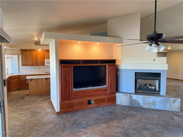 4455 W Ford Ave, Las Vegas, NV 89139 - unfurnished living room with lofted ceiling, ceiling fan, stone finish floors, and a fireplace