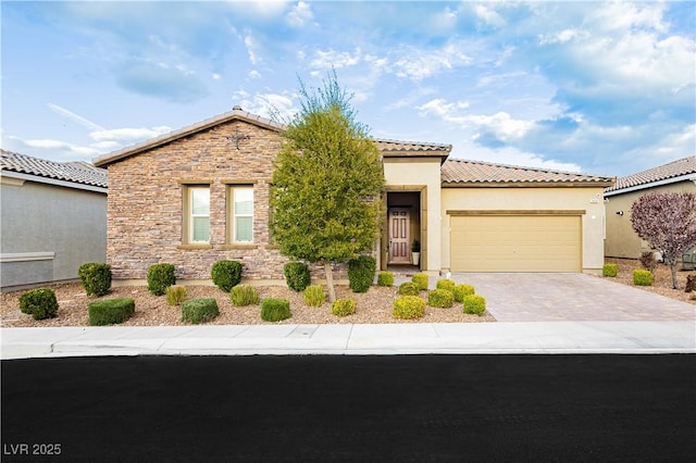 2450 Amatrice St, Henderson, NV 89044 - view of front of property featuring a garage, driveway, stone siding, stucco siding, and a tiled roof
