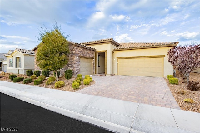 2450 Amatrice St, Henderson, NV 89044 - mediterranean / spanish-style home with an attached garage, decorative driveway, stucco siding, and a tiled roof