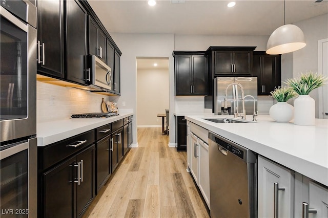 2450 Amatrice St, Henderson, NV 89044 - kitchen featuring appliances with stainless steel finishes, a sink, decorative backsplash, light countertops, and recessed lighting