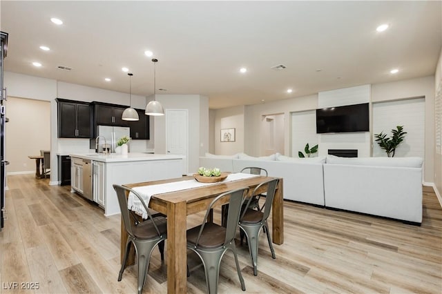2450 Amatrice St, Henderson, NV 89044 - dining area featuring light wood-type flooring, recessed lighting, a fireplace, and baseboards