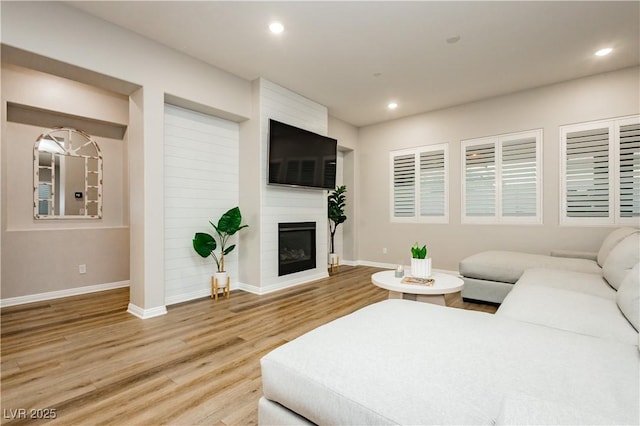2450 Amatrice St, Henderson, NV 89044 - living room with baseboards, light wood-type flooring, recessed lighting, and a large fireplace