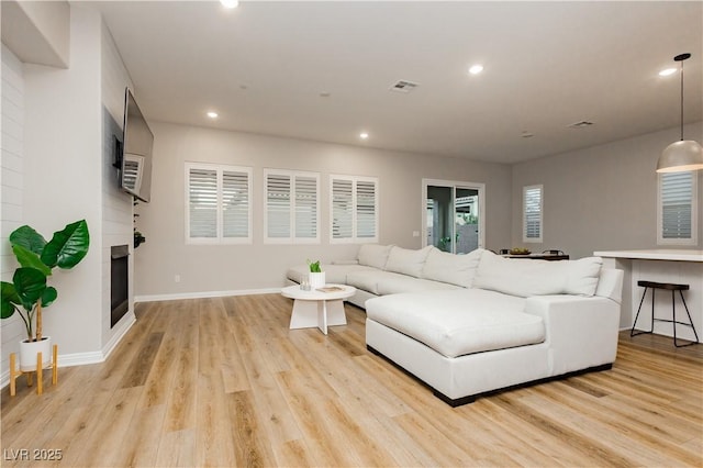 2450 Amatrice St, Henderson, NV 89044 - living room featuring light wood-style floors, recessed lighting, baseboards, and a glass covered fireplace