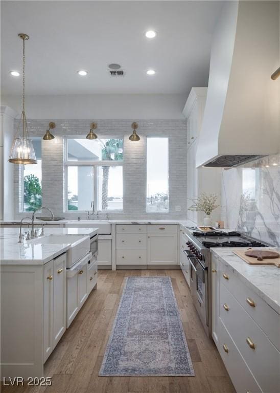 1610 Brock Ct, Las Vegas, NV 89117 - kitchen with wall chimney exhaust hood, high end range, a sink, tasteful backsplash, and recessed lighting