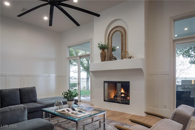 1610 Brock Ct, Las Vegas, NV 89117 - living area with a decorative wall, a glass covered fireplace, a ceiling fan, wood finished floors, and recessed lighting