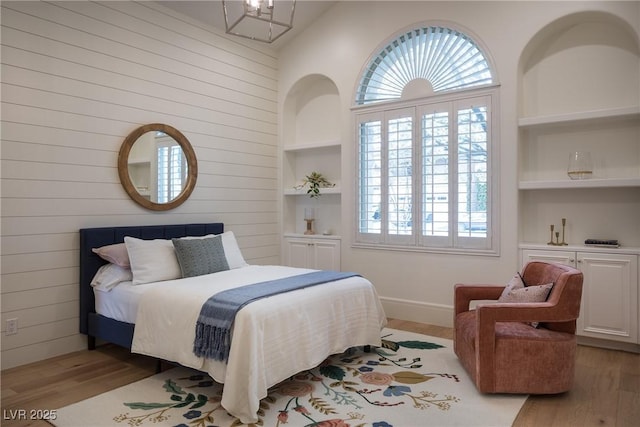 1610 Brock Ct, Las Vegas, NV 89117 - bedroom featuring light wood-style flooring, wooden walls, lofted ceiling, baseboards, and a chandelier