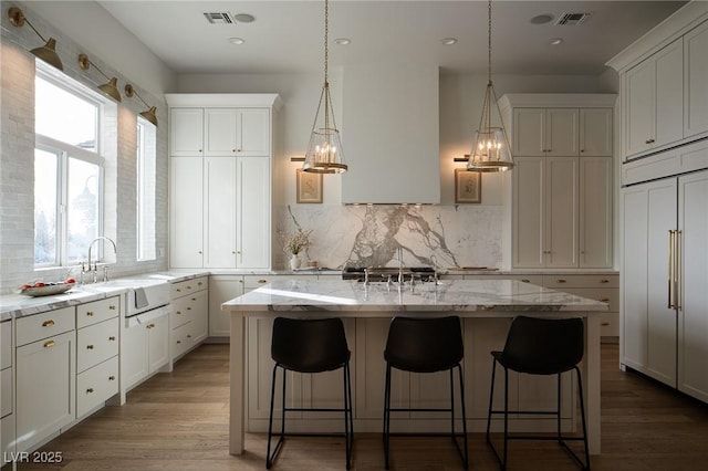 1610 Brock Ct, Las Vegas, NV 89117 - kitchen featuring paneled fridge, a sink, backsplash, a kitchen bar, and recessed lighting