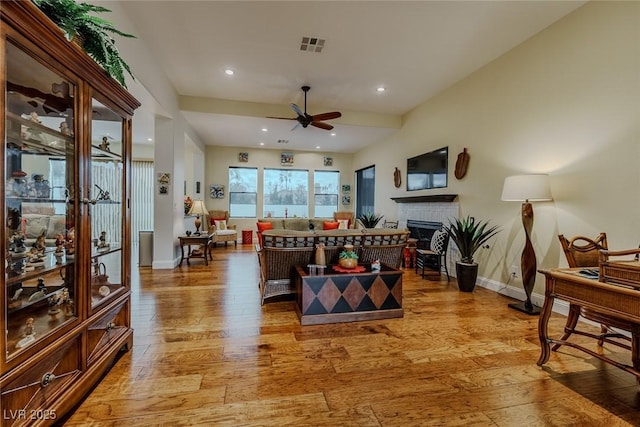 11477 Timber Mountain Ave, Las Vegas, NV 89135 - living area featuring a ceiling fan, light wood-style flooring, a fireplace, baseboards, and recessed lighting