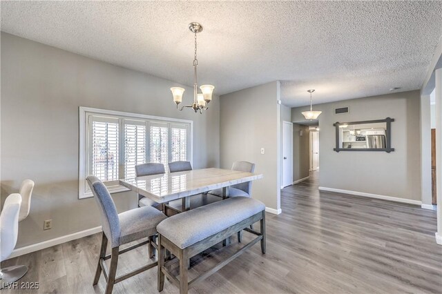 1157 Morning Sun Way, Las Vegas, NV 89110 - dining room with a textured ceiling, light wood-style flooring, baseboards, and a chandelier