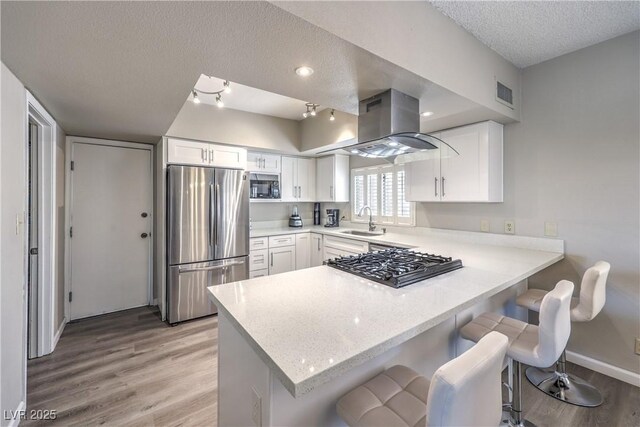 1157 Morning Sun Way, Las Vegas, NV 89110 - kitchen featuring freestanding refrigerator, island exhaust hood, a sink, black microwave, and a textured ceiling