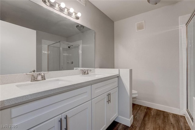 7905 Idledale Ct Unit 102, Las Vegas, NV 89145 - bathroom featuring a shower stall, wood finished floors, baseboards, and double vanity
