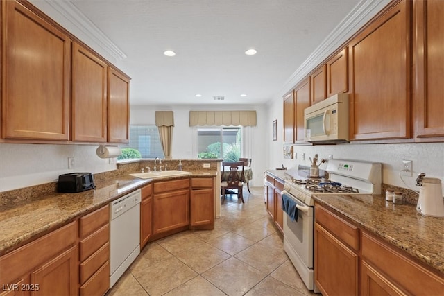 2108 Willow Wren Dr, North Las Vegas, NV 89084 - kitchen with white appliances, a sink, brown cabinetry, a peninsula, and ornamental molding