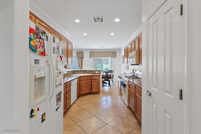 2108 Willow Wren Dr, North Las Vegas, NV 89084 - kitchen featuring white appliances, a sink, brown cabinets, light tile patterned flooring, and a peninsula