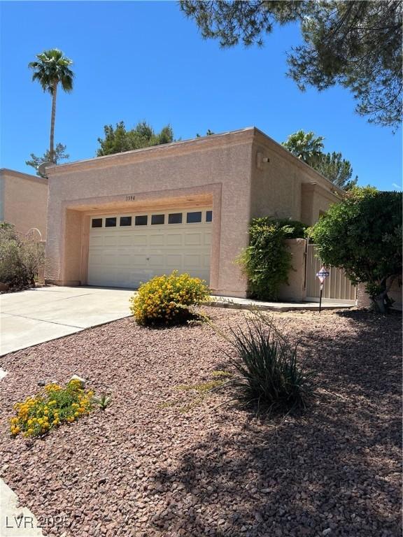 3394 Brookfield Dr, Las Vegas, NV 89120 - view of side of property featuring stucco siding, an attached garage, and concrete driveway