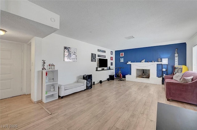3018 Burnham Ave, Las Vegas, NV 89169 - living area featuring a textured ceiling, light wood-style flooring, and a brick fireplace