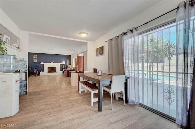 3018 Burnham Ave, Las Vegas, NV 89169 - dining room with a fireplace, light wood-type flooring, and a textured ceiling