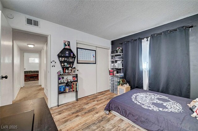 3018 Burnham Ave, Las Vegas, NV 89169 - bedroom with wood finished floors, a textured ceiling, and a closet