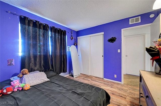 3018 Burnham Ave, Las Vegas, NV 89169 - bedroom featuring wood finished floors, a textured ceiling, and a closet