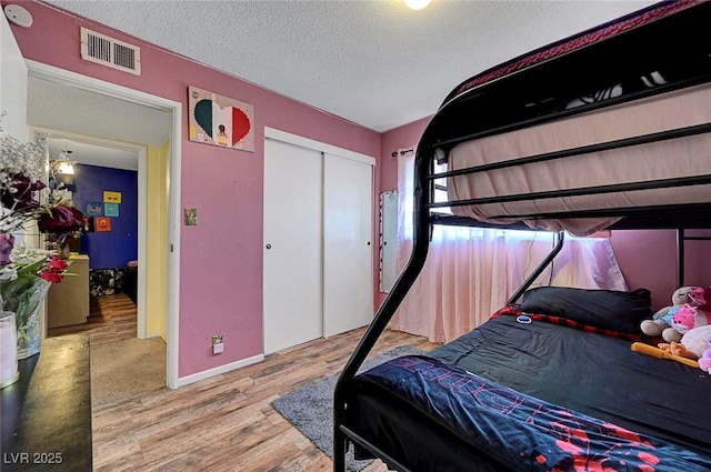 3018 Burnham Ave, Las Vegas, NV 89169 - bedroom with wood finished floors, a textured ceiling, a closet, and baseboards