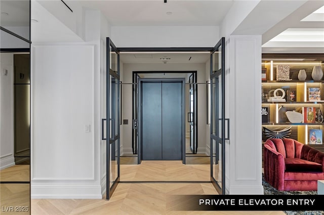 hall featuring elevator and baseboards