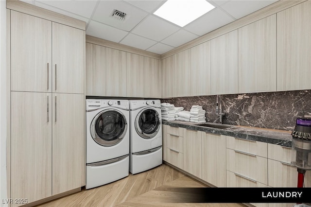 washroom with washing machine and dryer and cabinet space
