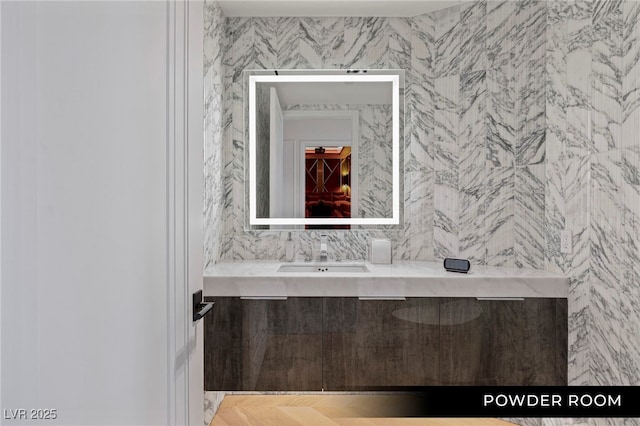 bathroom featuring vanity and tile walls