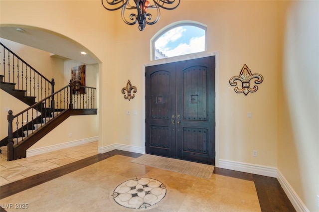 9749 Glistening Brook Ct, Las Vegas, NV 89149 - foyer entrance with inlaid floor details, a high ceiling, arched walkways, stairway, and baseboards