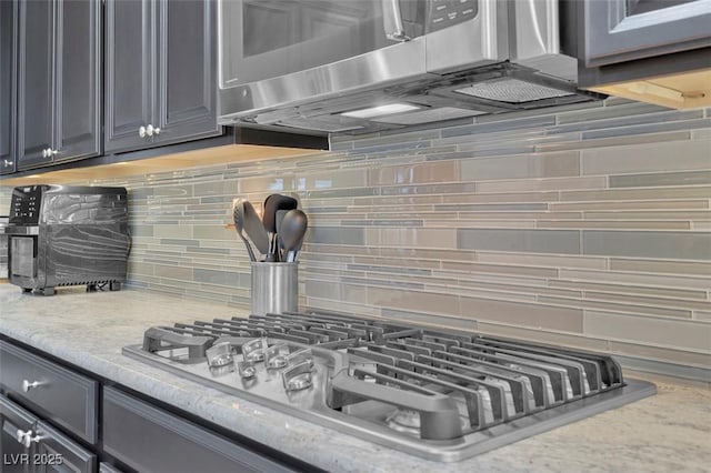 kitchen view of stainless steel appliances and decorative backsplash