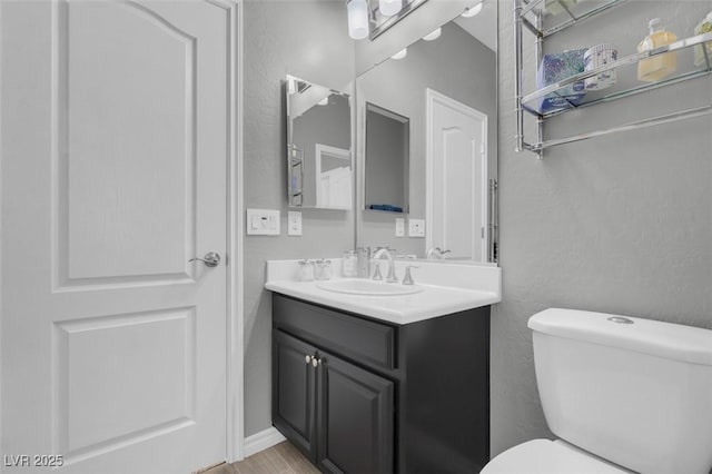 bathroom featuring toilet and vanity