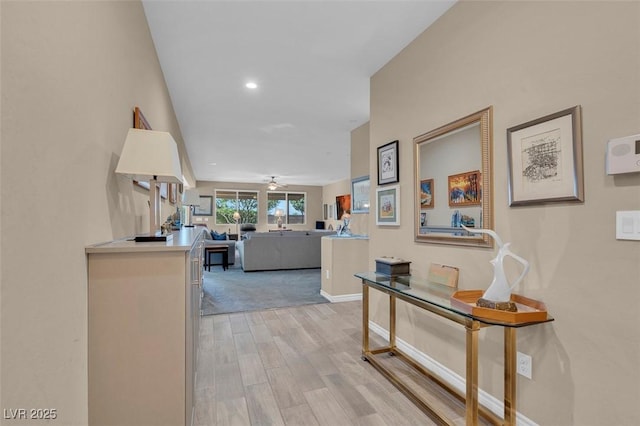 hall with light wood-style floors, baseboards, and recessed lighting