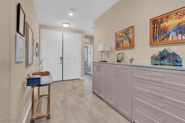 entryway featuring baseboards, light wood-style flooring, and recessed lighting