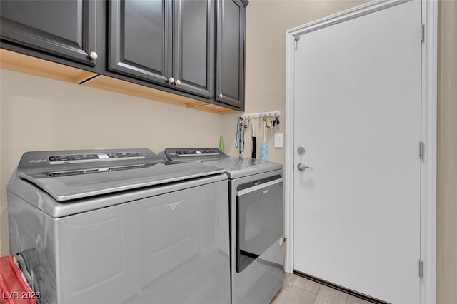 washroom featuring washer and dryer and cabinet space