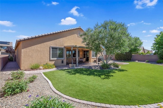 rear view of house with stucco siding, a patio, and a tile roof
