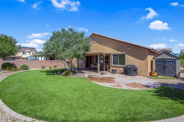 rear view of house with a storage unit, stucco siding, an outbuilding, a patio area, and a tile roof