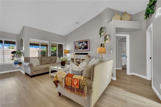 4617 Mancilla St, Las Vegas, NV 89130 - living area featuring high vaulted ceiling, light wood-type flooring, plenty of natural light, and baseboards