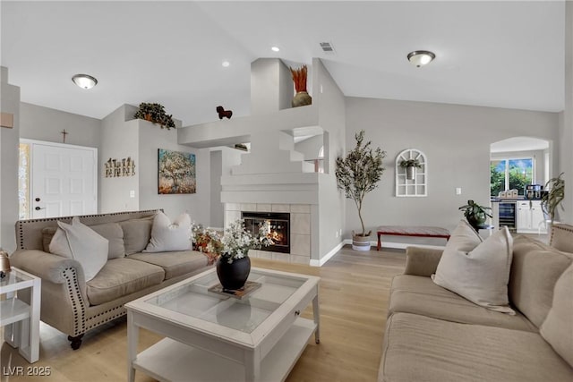 4617 Mancilla St, Las Vegas, NV 89130 - living room featuring wine cooler, light wood-type flooring, a tile fireplace, baseboards, and high vaulted ceiling