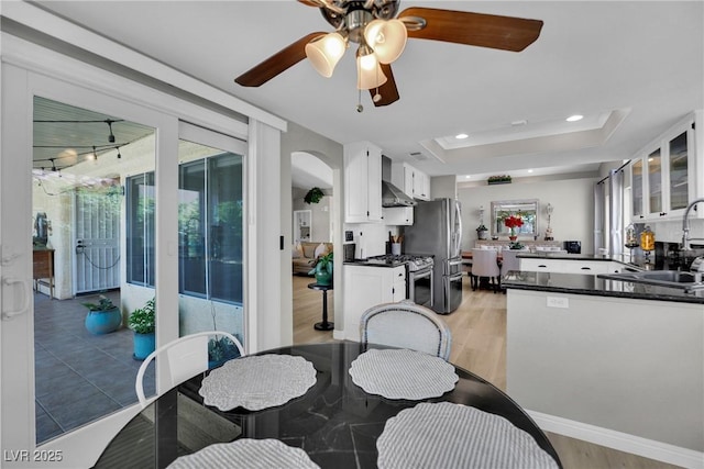 4617 Mancilla St, Las Vegas, NV 89130 - dining area featuring light wood-style floors, arched walkways, ceiling fan, a raised ceiling, and recessed lighting