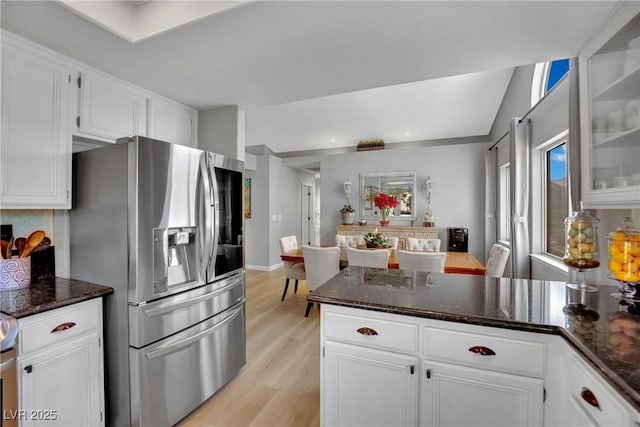 4617 Mancilla St, Las Vegas, NV 89130 - kitchen featuring stainless steel fridge with ice dispenser, light wood-style flooring, white cabinets, tasteful backsplash, and dark stone countertops
