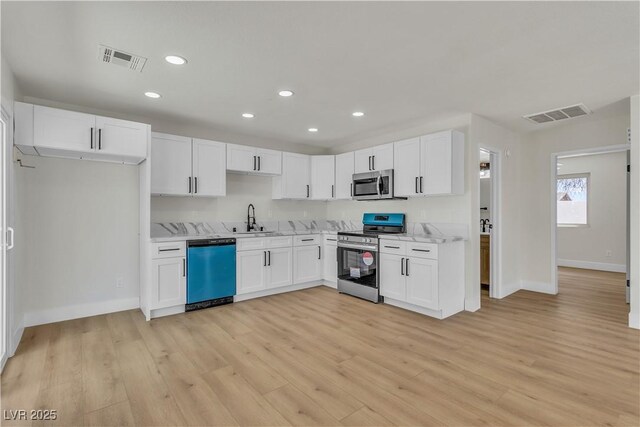 4061 W Eldorado Ln, Las Vegas, NV 89139 - kitchen featuring stainless steel appliances, white cabinetry, a sink, light wood-type flooring, and recessed lighting