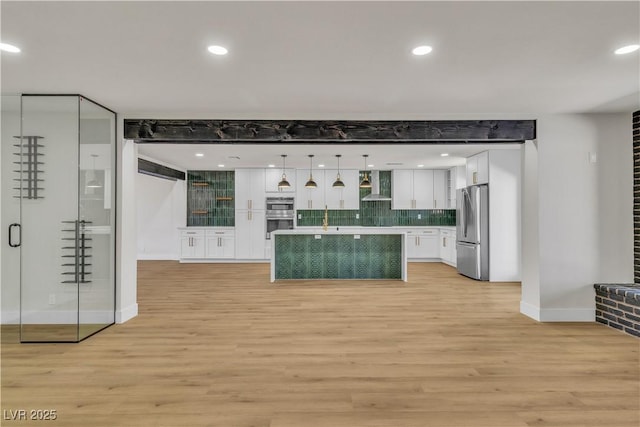 4061 W Eldorado Ln, Las Vegas, NV 89139 - kitchen featuring wall chimney range hood, stainless steel appliances, white cabinetry, light wood-style floors, and baseboards